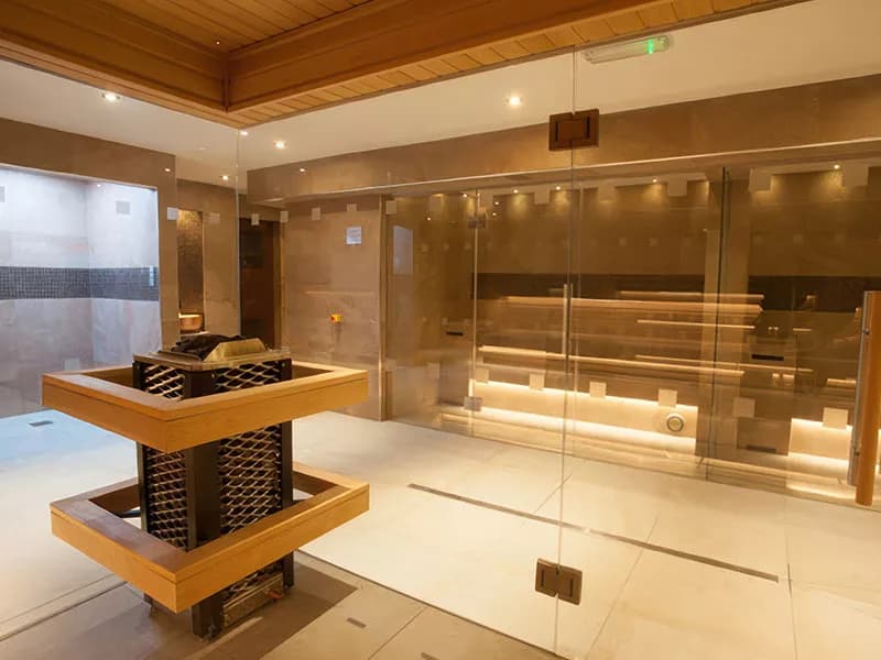 Contemporary thermal suite at Netherwood Hotel and Spa in Grange-over-Sands featuring traditional dry heat sauna with glass walls, natural timber construction, salt inhalation room visible through doorway, sophisticated wellness facilities in Victorian mansion overlooking Morecambe Bay Netherwood Hotel